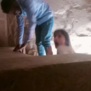 Spiritual seekers ascending through the narrow initiation passage inside a Great Pyramid chamber in Egypt