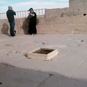 Tourists exploring the rooftop energy grid of Dendera Temple of Goddess Hathor in Egypt